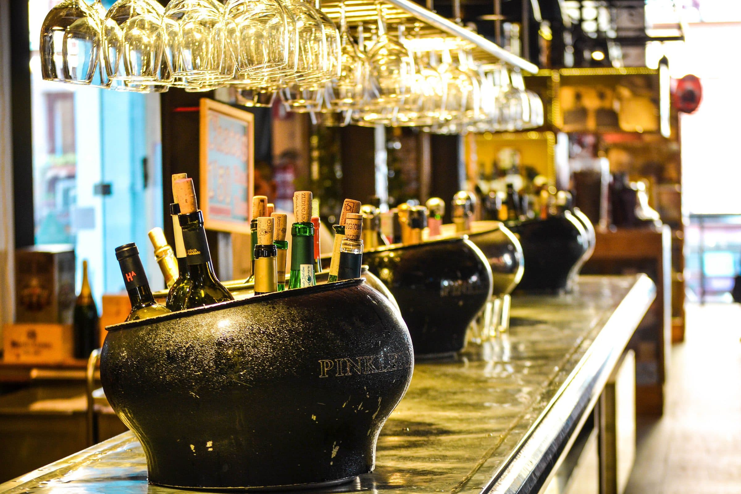 The bar counter at night, glasses and bottles in warm light